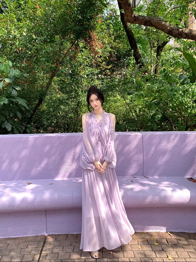 Woman wearing a lavender sleeveless pleated maxi dress outdoors