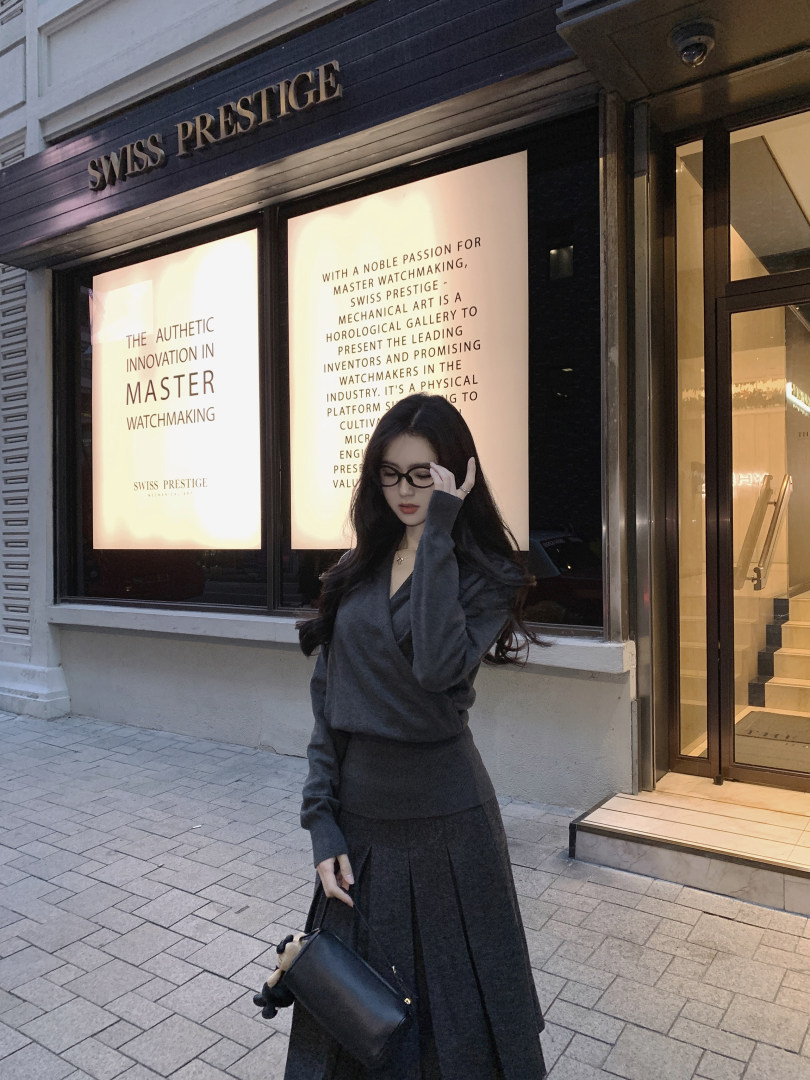 Woman wearing a gray outfit standing in front of a store with text displays