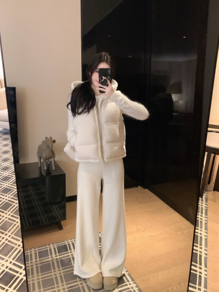 Woman wearing a white puffer jacket and matching wide-leg pants in a mirror selfie.
