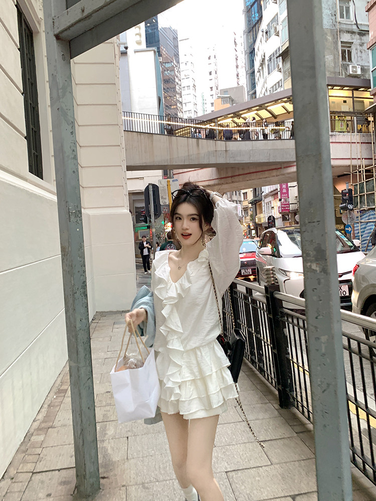Woman wearing white ruffled dress walking on a city street