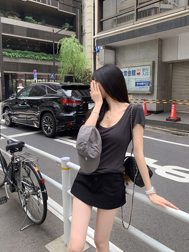 Woman wearing a black top and shorts on a city street