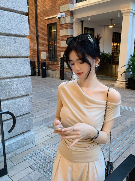 Woman wearing a beige one-shoulder dress outdoors