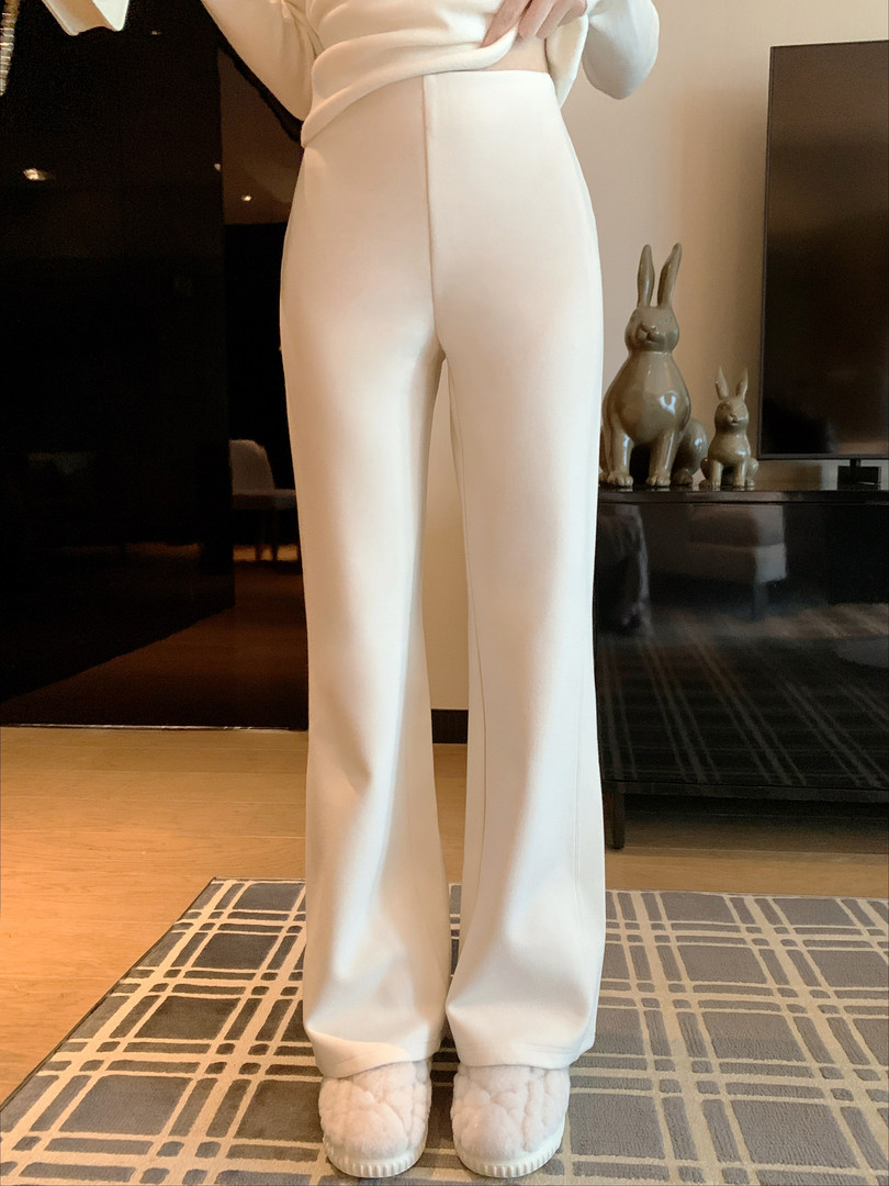 White wide-leg pants worn by a model indoors with slippers