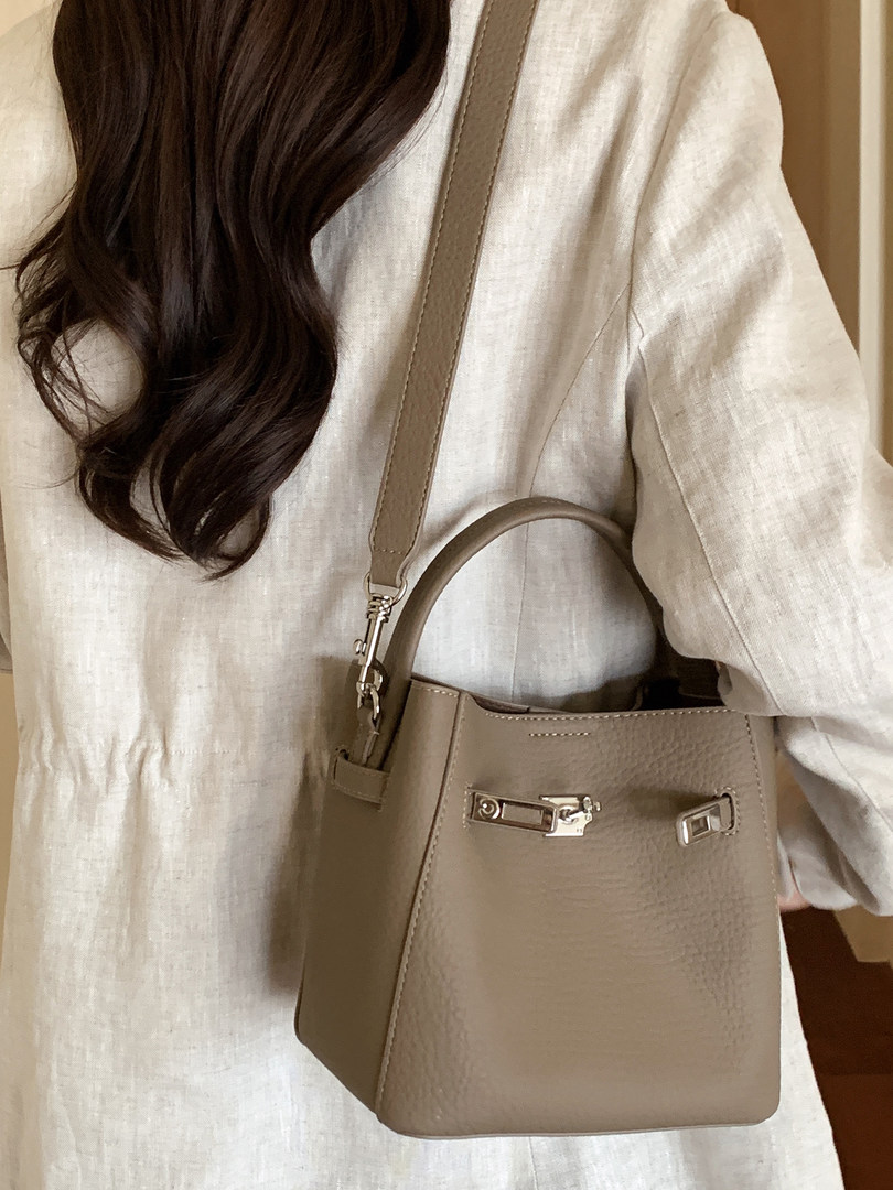 Taupe leather handbag worn on a model