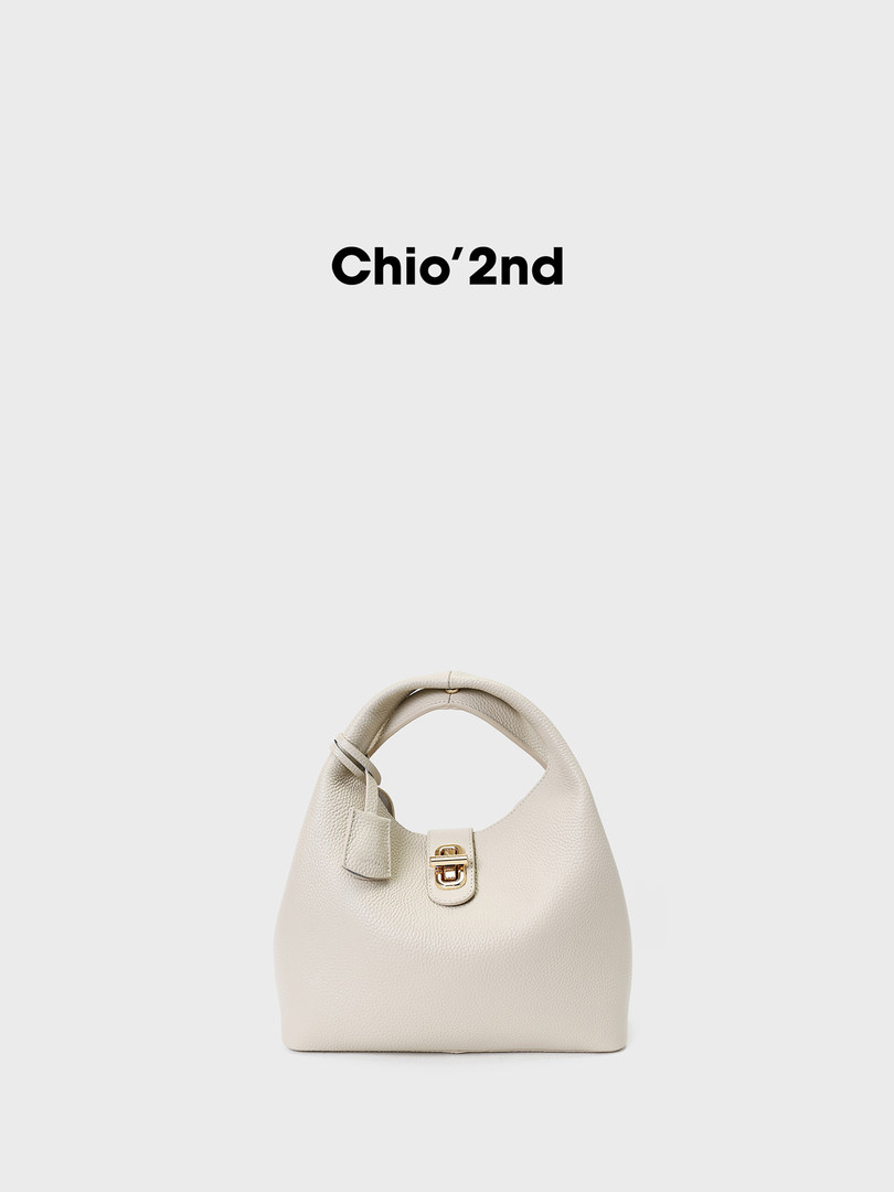 White leather handbag with gold clasp on a plain background