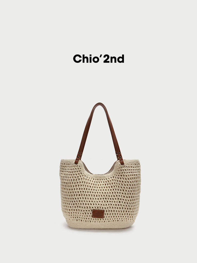 Cream woven tote bag with brown handles on a white background