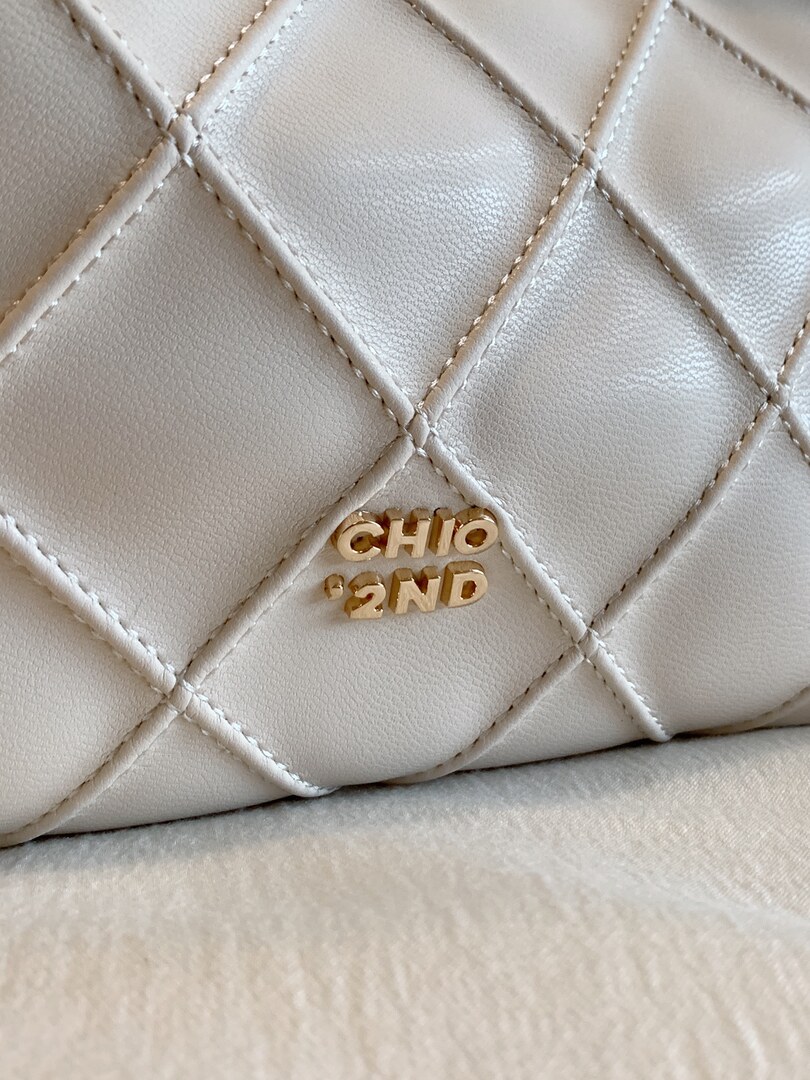 Close-up of a quilted cream leather handbag with gold CHIO 2ND hardware