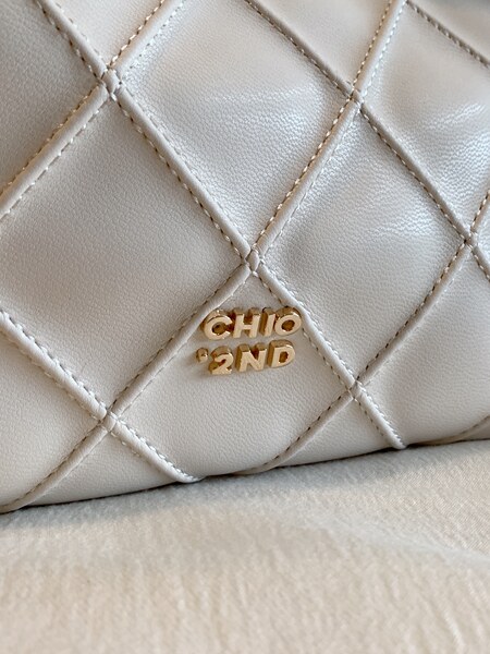 Close-up of a quilted cream leather handbag with gold CHIO 2ND hardware
