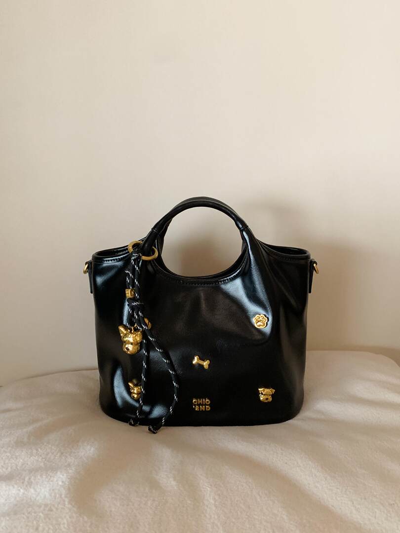 Black glossy handbag with gold charms and top handle
