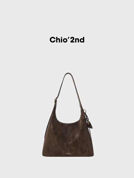 Brown leather shoulder handbag with long strap on a plain background