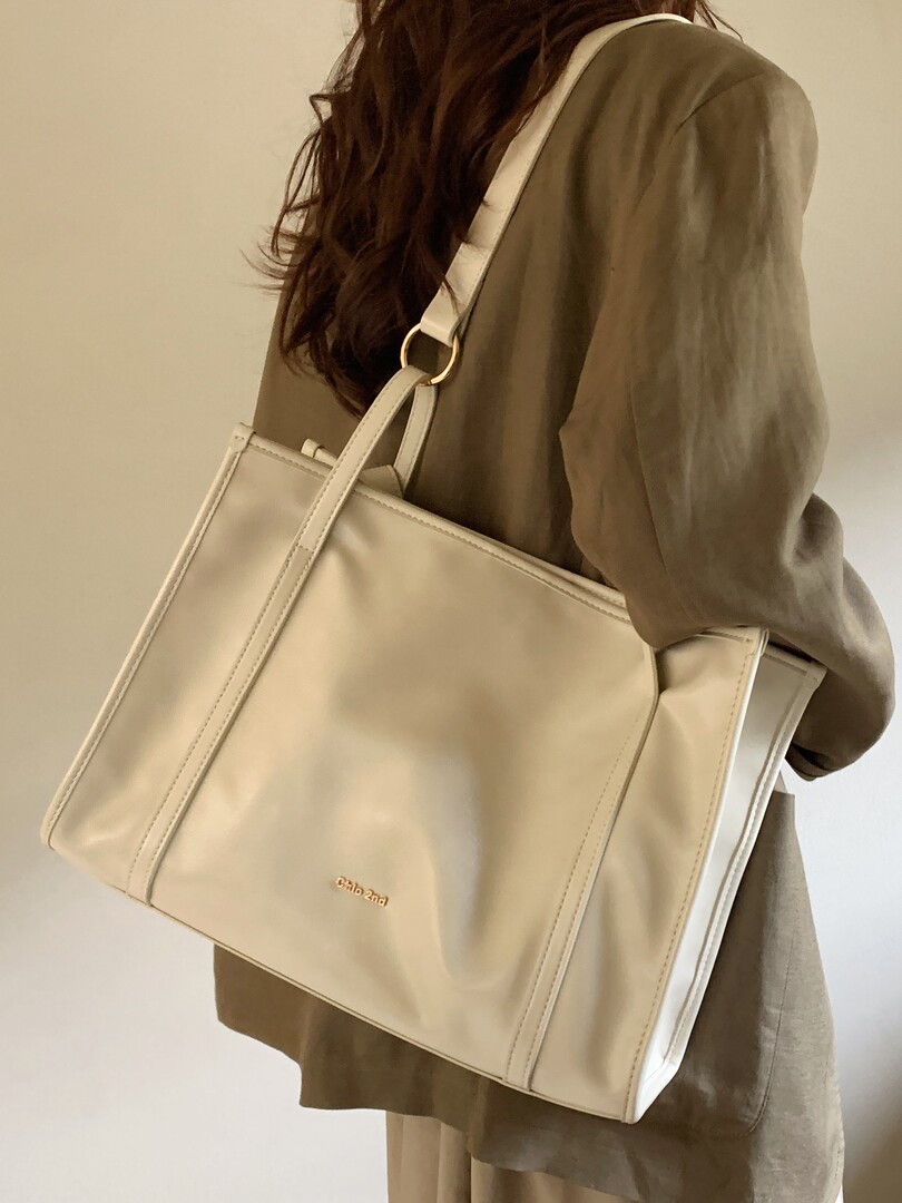 Beige oversized tote bag worn on the shoulder