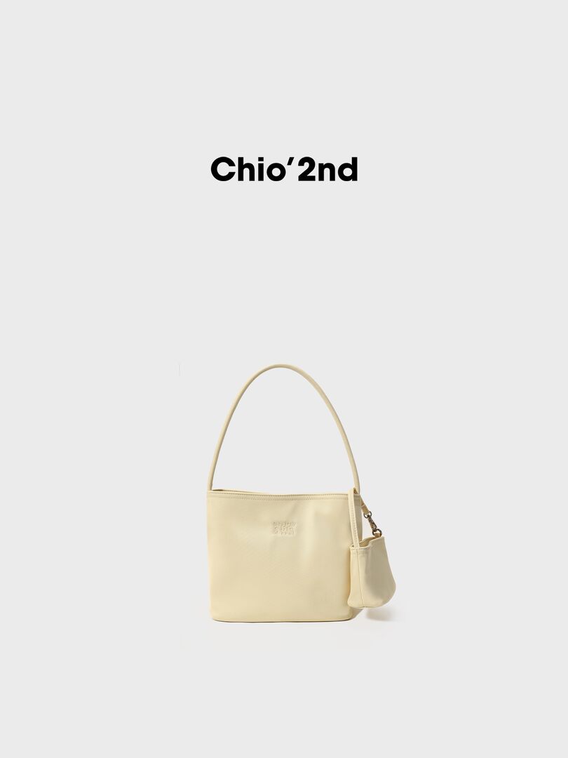 Cream shoulder handbag with a small matching pouch on a white background