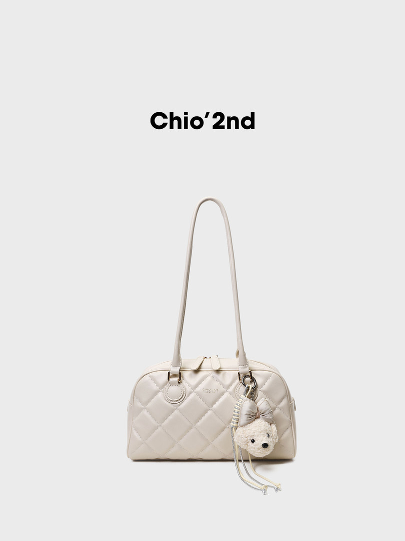 Cream quilted handbag with long shoulder straps and teddy bear charm