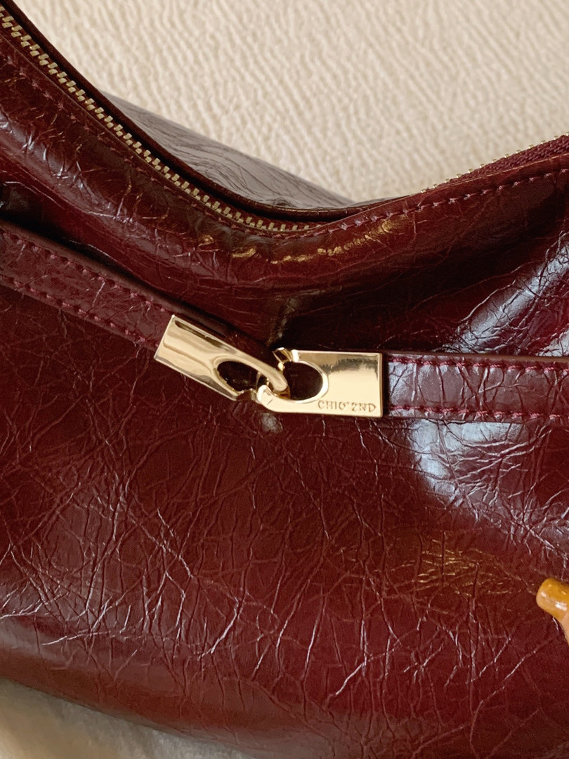 Burgundy leather handbag with gold zipper hardware