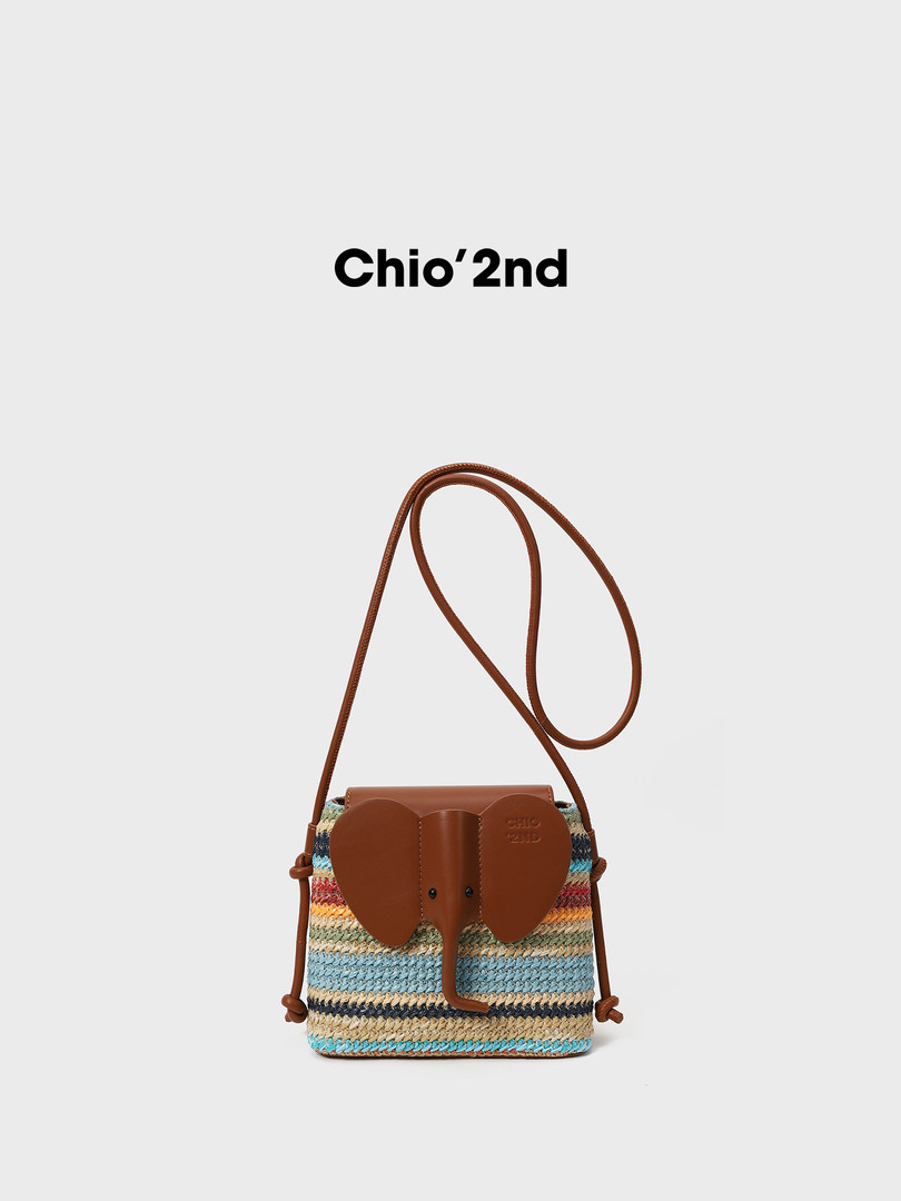 Multicolor woven crossbody handbag with brown elephant flap and strap on a white background