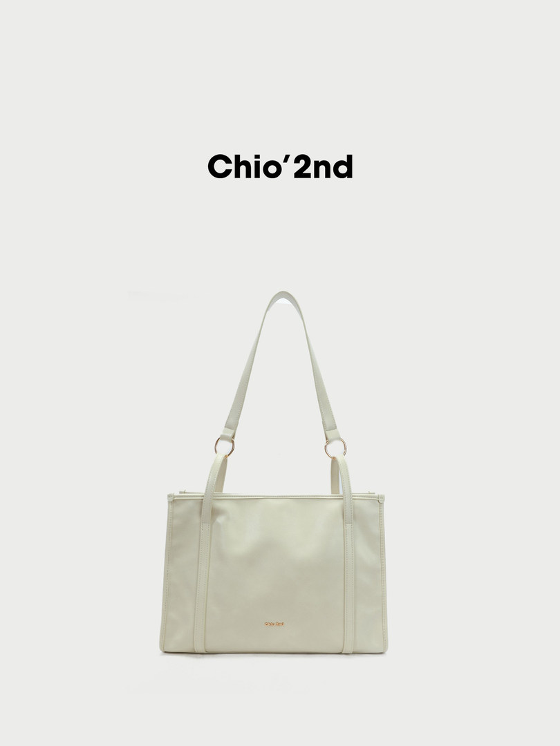 Light beige tote bag with long shoulder straps on a white background