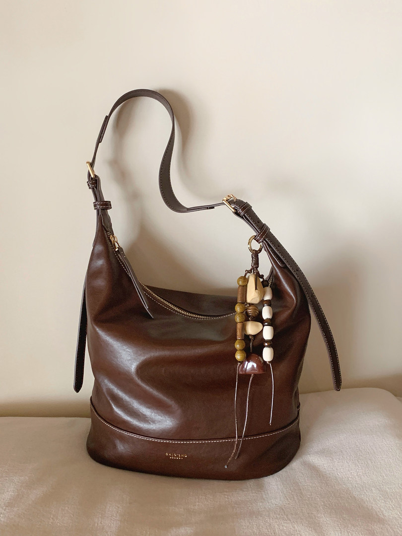 Brown leather shoulder handbag with decorative beaded charm