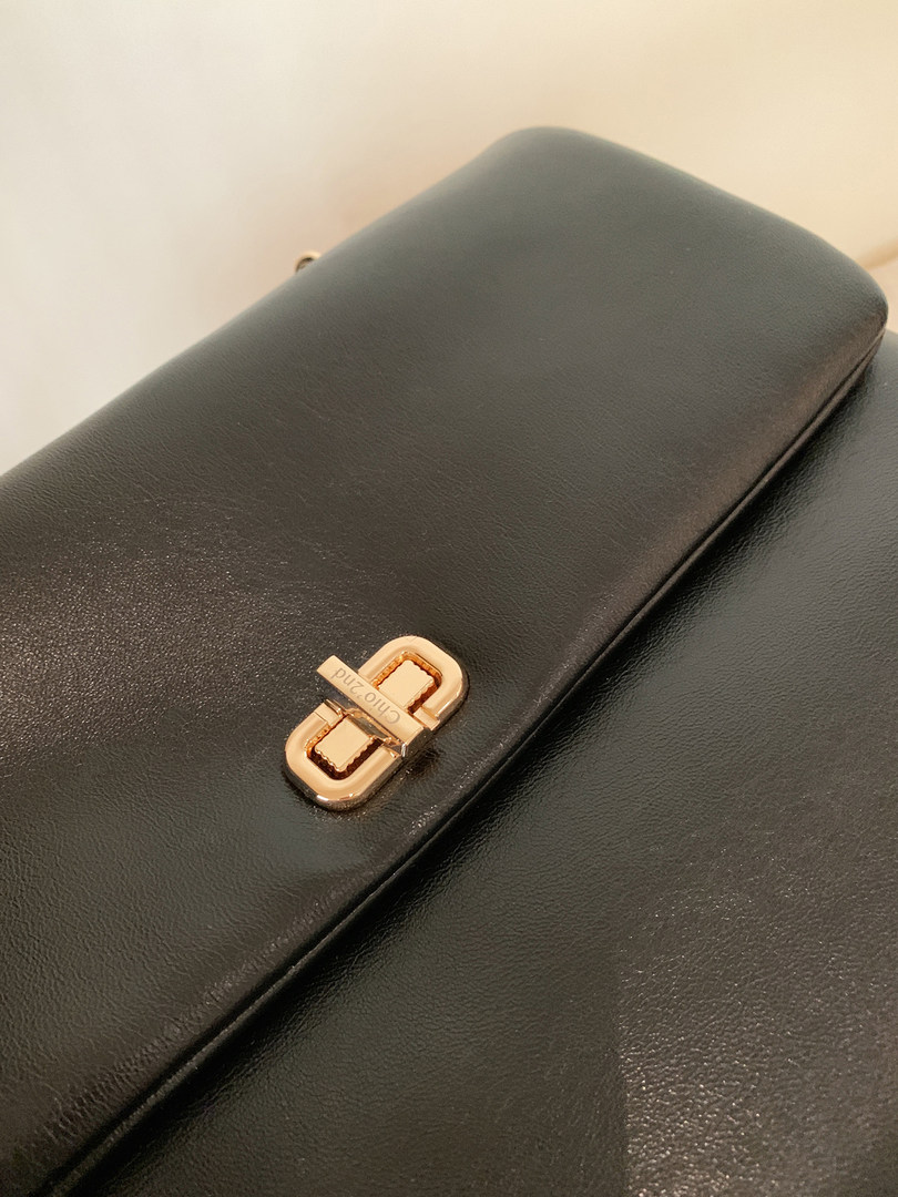 Black leather handbag clutch with gold clasp detail
