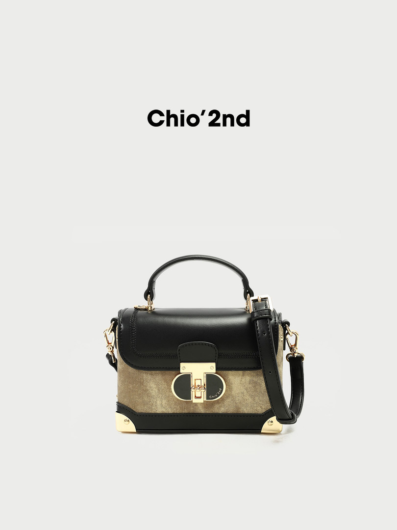 Black and beige structured crossbody handbag with gold hardware and shoulder strap
