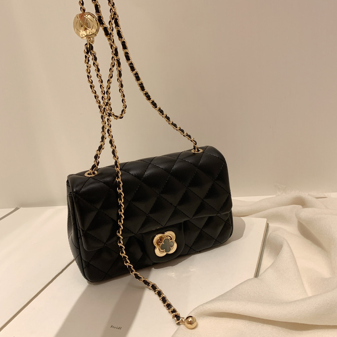 Black quilted chain-strap shoulder bag on a neutral background