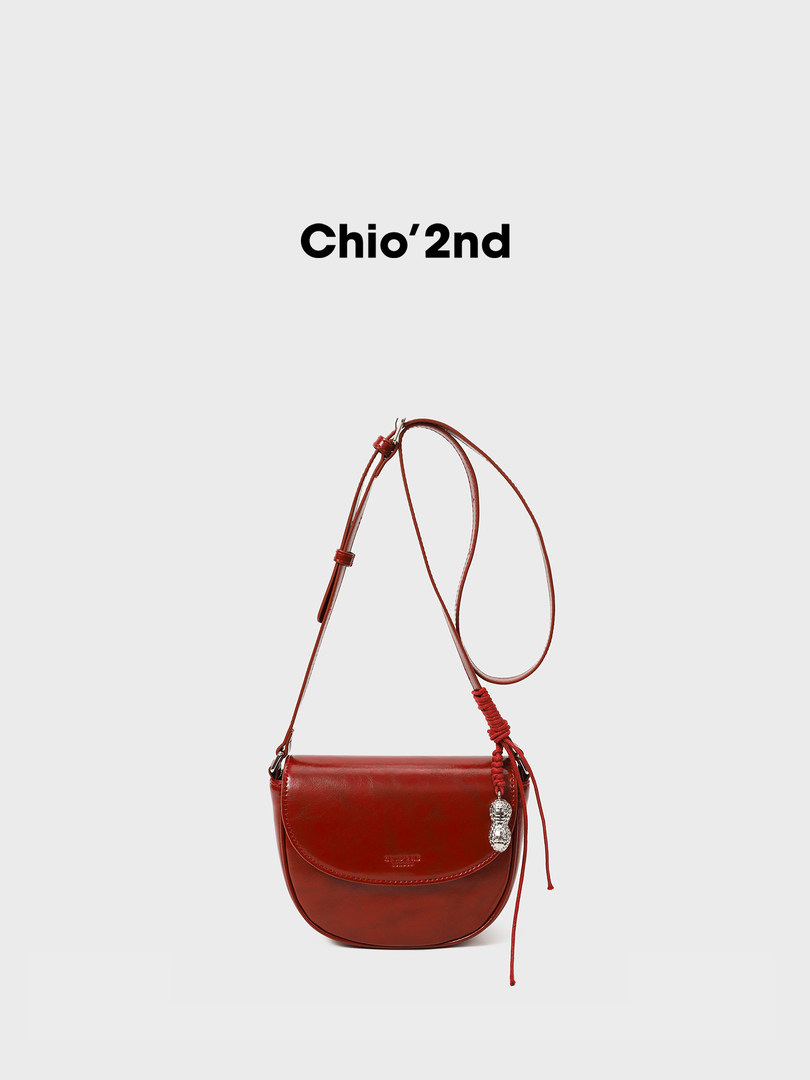 Red leather crossbody handbag on a white background