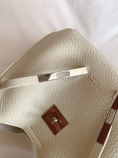Beige textured leather handbag with metallic hardware
