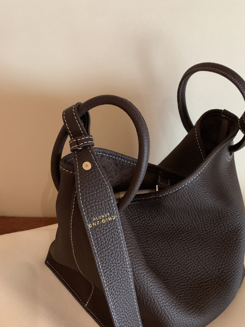 Dark brown textured leather handbag with loop handles and contrast stitching