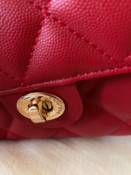 Close-up of a red quilted handbag with a gold clasp
