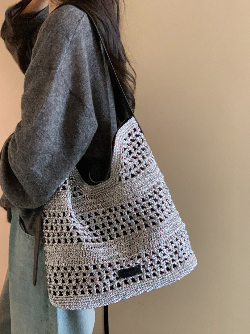 Woven tote bag worn on a person’s shoulder