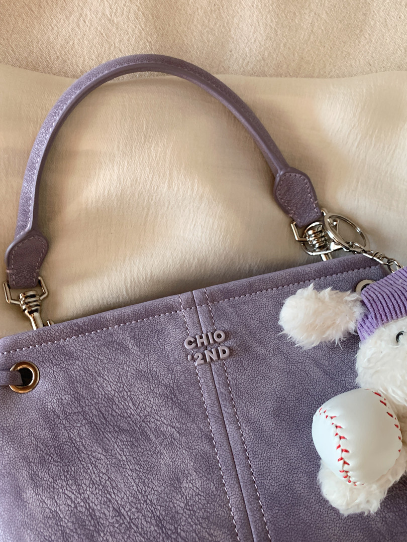 Lavender textured handbag with top handle and plush charm keychain