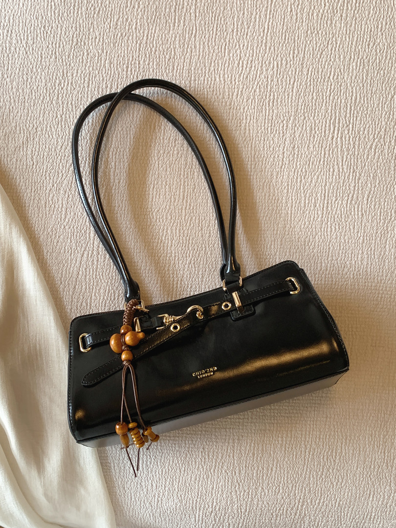 Black leather handbag with long handles and gold hardware