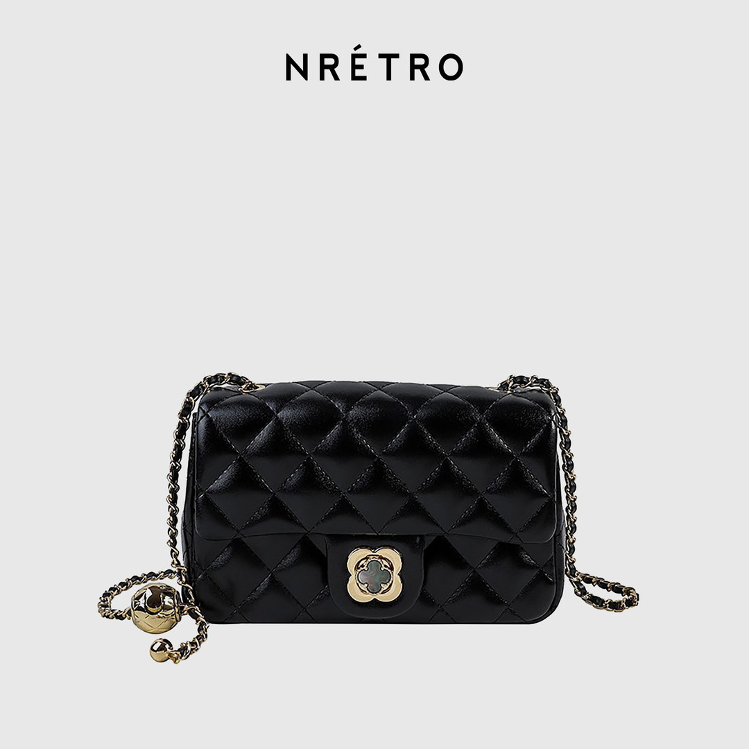 Black quilted chain-strap handbag on a plain background