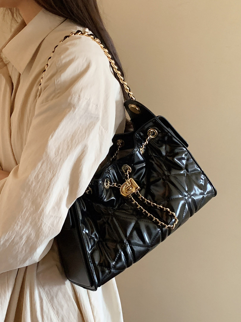 Black quilted chain-strap handbag worn on shoulder
