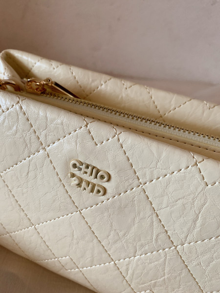 Cream quilted leather handbag with gold zipper and logo detail