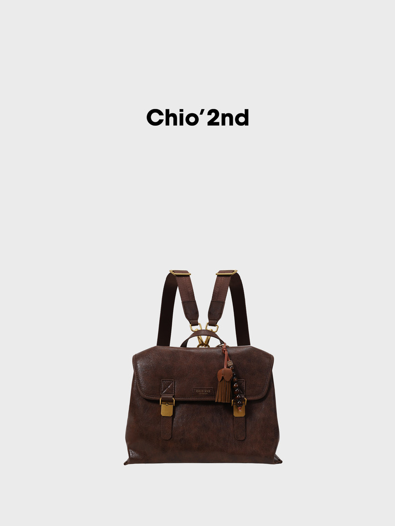 Brown leather backpack with gold hardware on a plain background