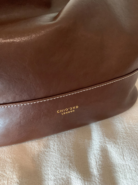 Close-up of a brown leather bag with CHIO•2ND LONDON logo