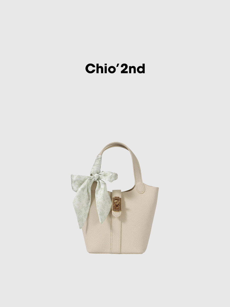 Beige textured handbag with a decorative scarf bow and gold clasp