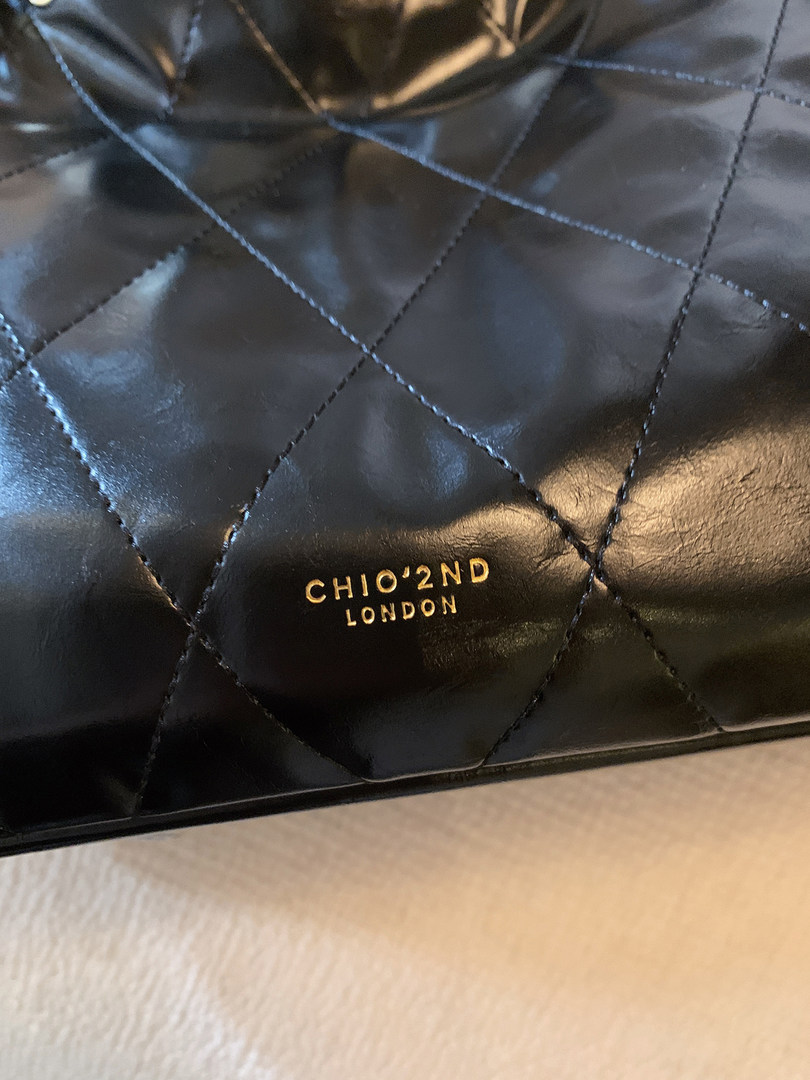 Close-up of a black quilted leather handbag with CHIO'2ND London logo