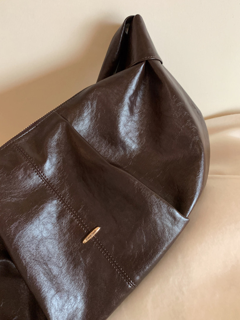 Brown leather handbag close-up on a neutral background