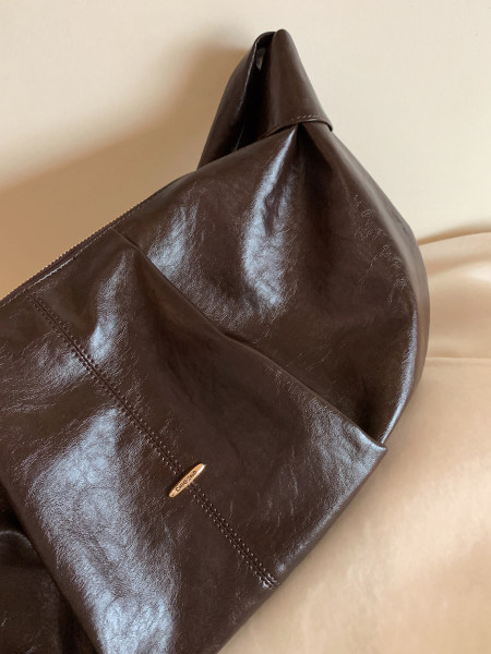Brown leather handbag close-up on a neutral background