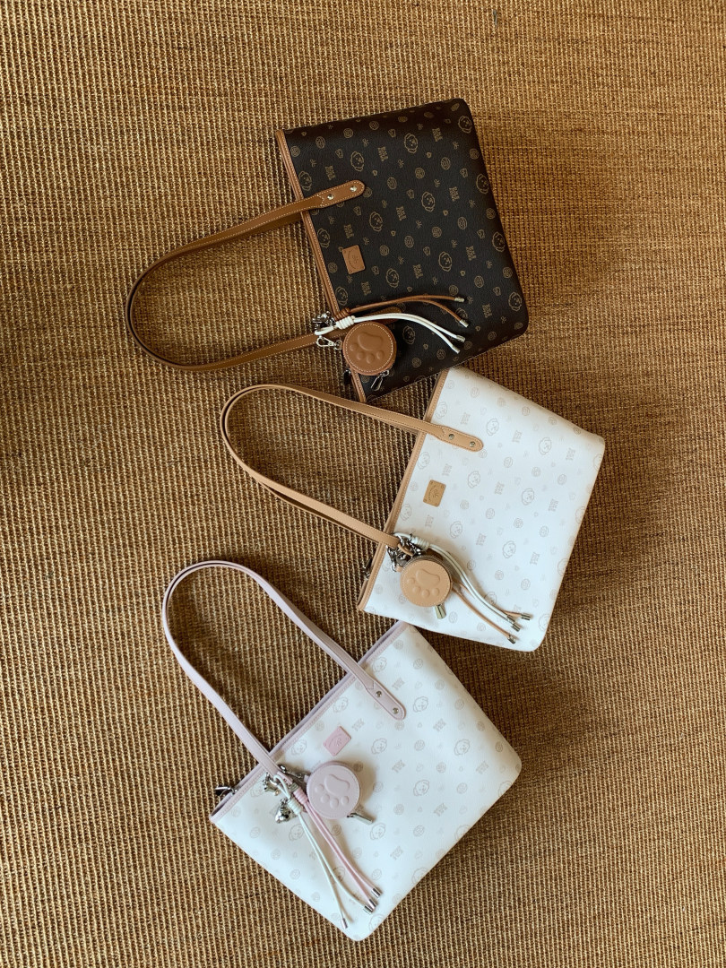 Three patterned tote handbags laid on a woven mat