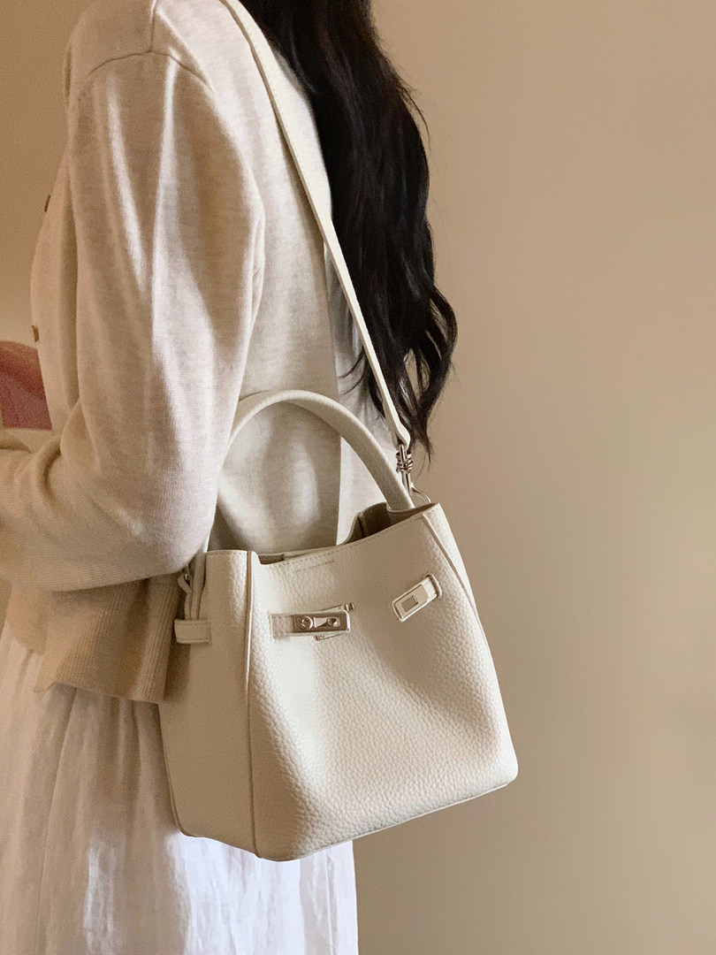 Cream leather handbag worn crossbody on a model