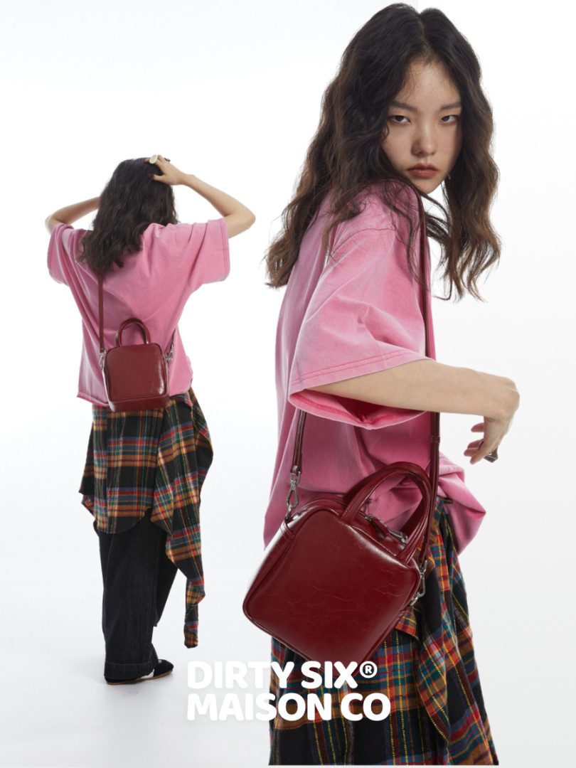 Burgundy mini leather crossbody backpack worn by a model
