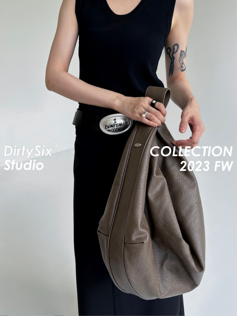 Model holding a large brown leather shoulder bag