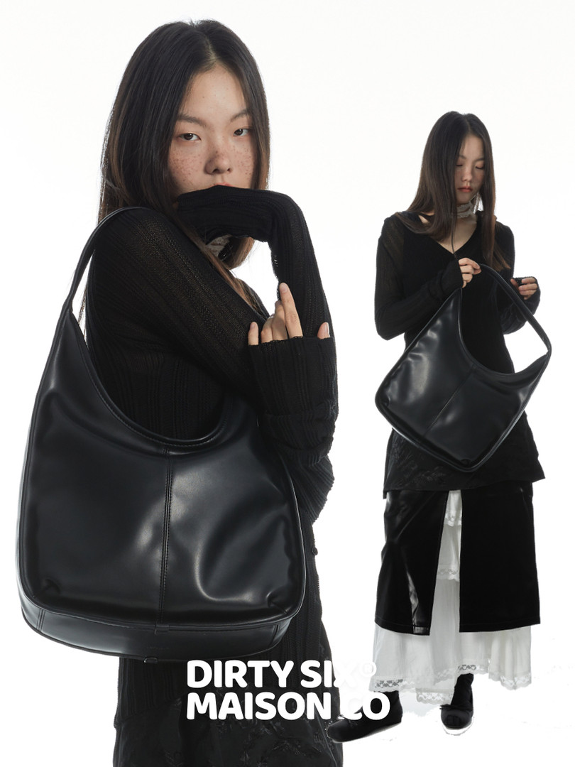 Black leather shoulder handbag shown on a model against a white background