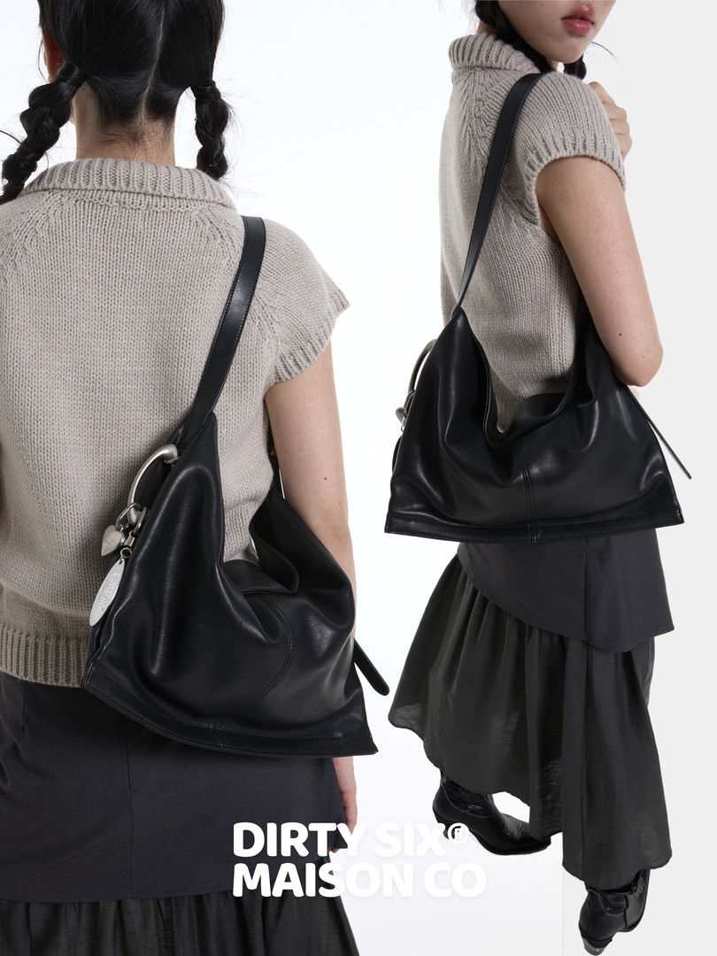 Black shoulder bag worn by a model with a monochrome outfit