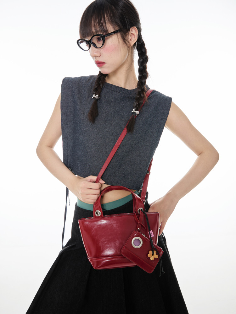 Red leather handbag worn by a model with matching small pouch