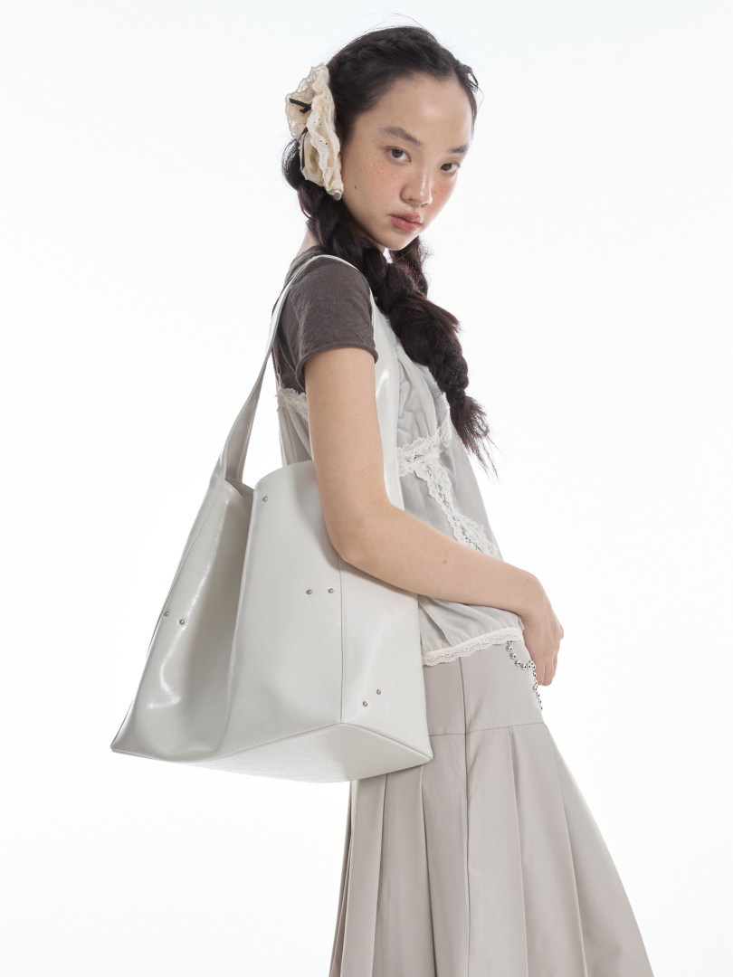 Light gray oversized tote bag worn by a model in a studio