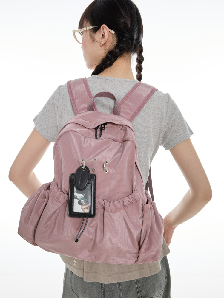 Pink backpack worn on a model against a white background