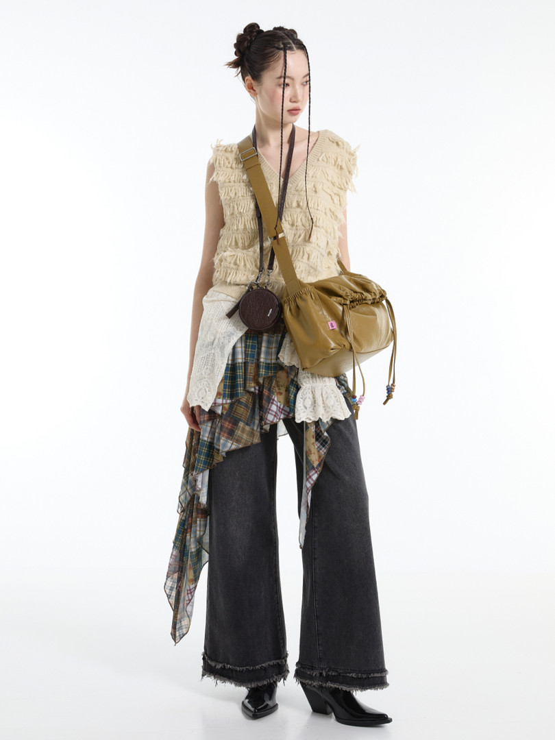 Model wearing a layered boho-inspired outfit with a tan crossbody bag